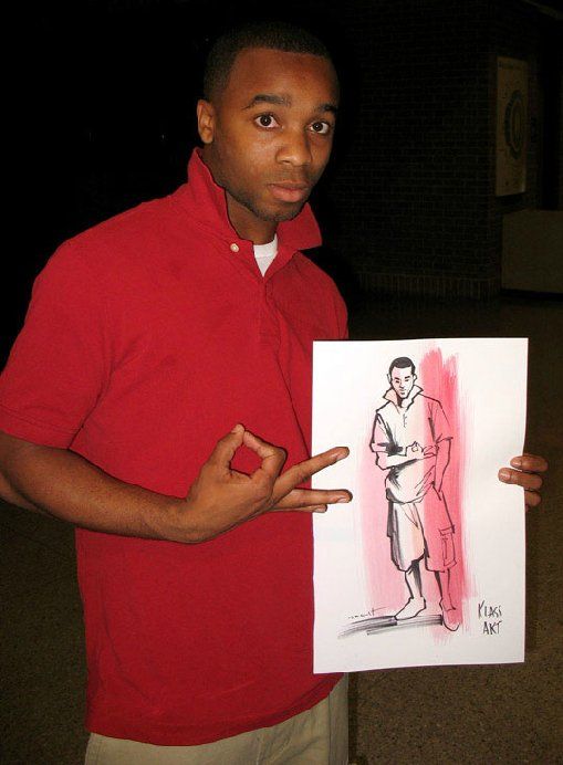A man in a red shirt is holding a drawing of a man