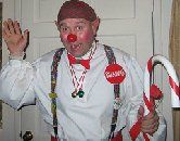 A man dressed as a clown is holding a candy cane.