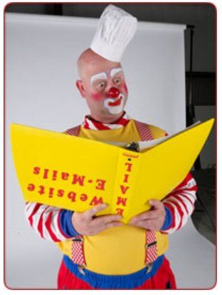 A clown wearing a chef 's hat is reading a book about e-mails