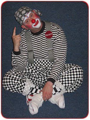 A man dressed as a clown is sitting on the floor