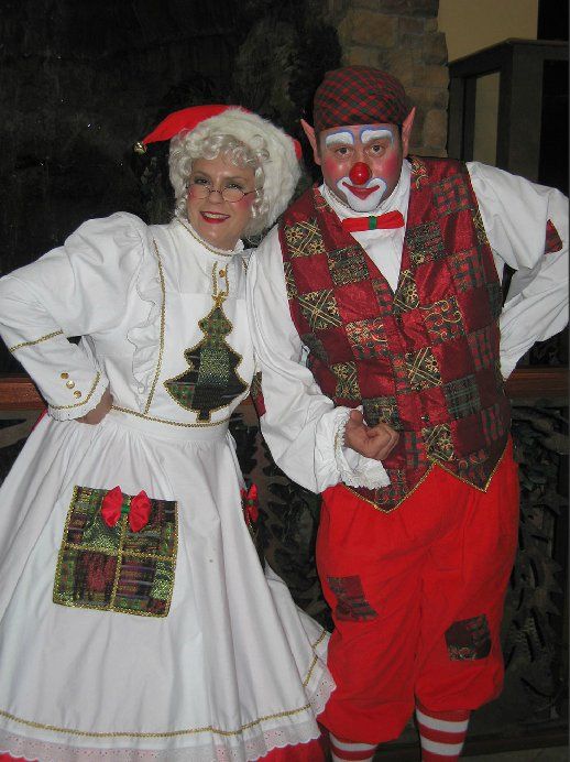 A man and a woman dressed as clowns posing for a picture