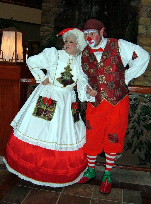 A man and a woman dressed as clowns standing next to each other