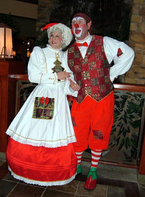 A man and a woman dressed as clowns standing next to each other