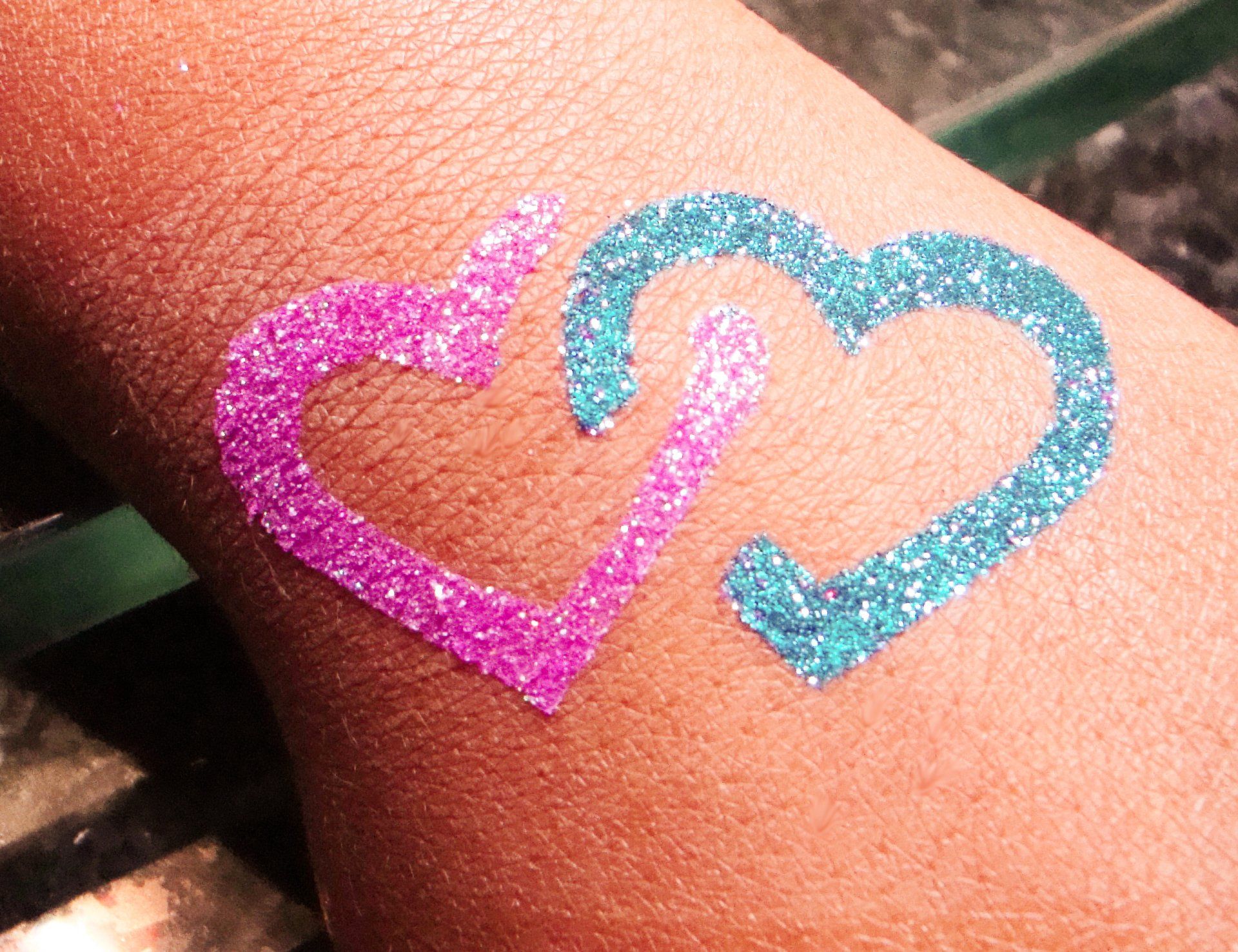 A person has two hearts painted on their wrist