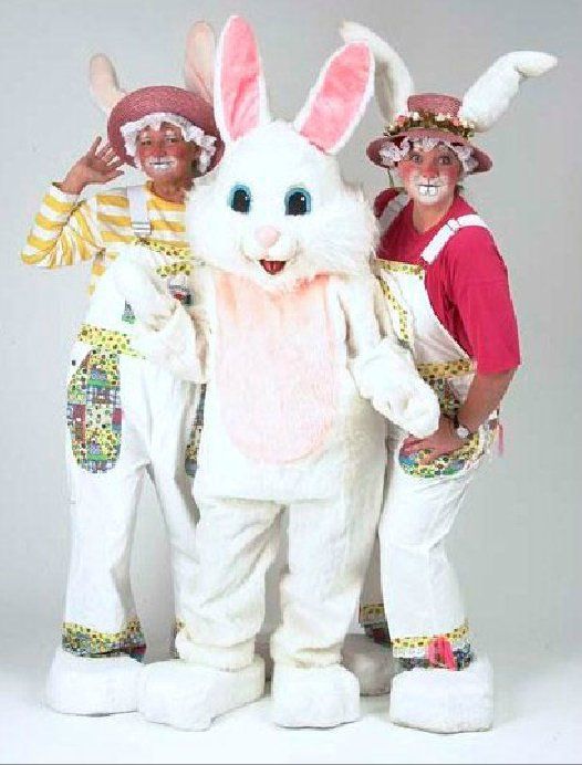 Two clowns standing next to a white bunny mascot