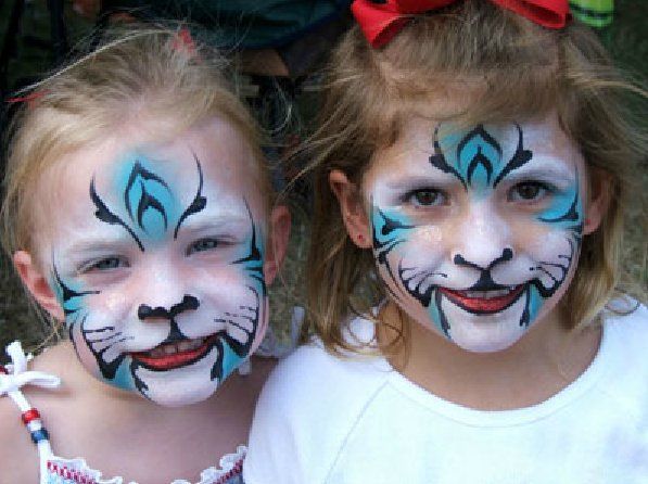 Two little girls with their faces painted like tigers