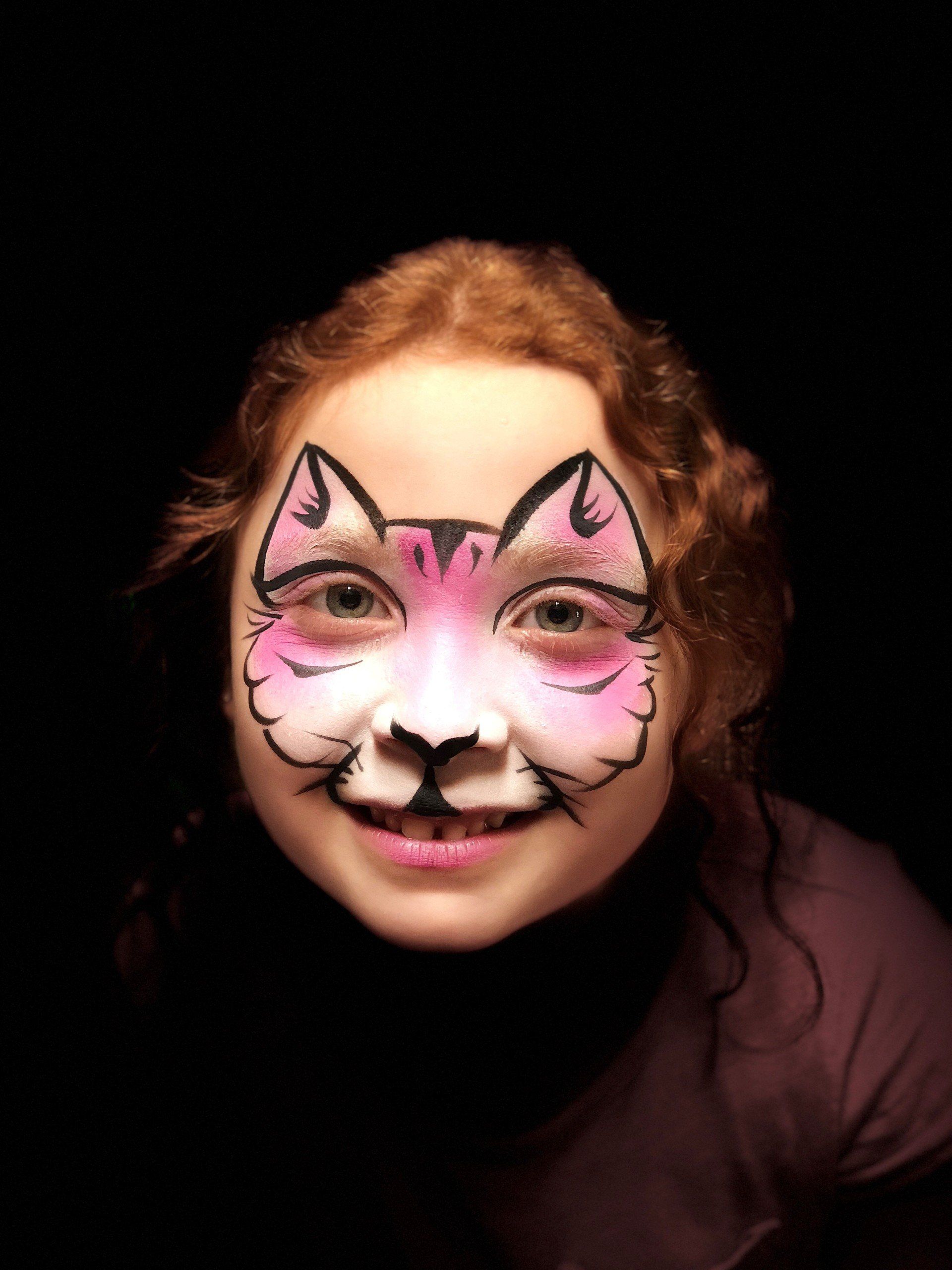 A little girl with her face painted like a cat