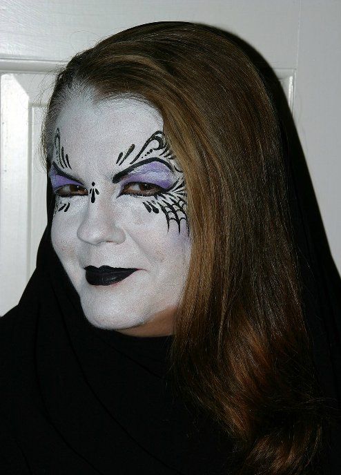 A woman with a spider web painted on her face