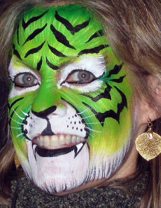 A woman has her face painted like a tiger