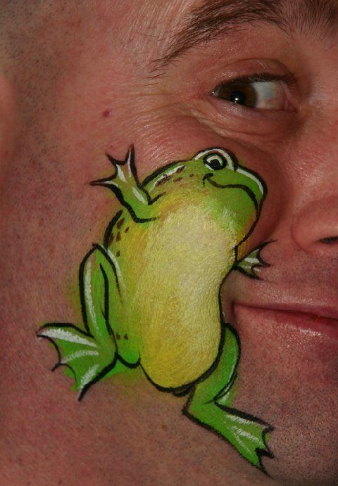 A man has a frog painted on his face.