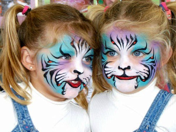 Two little girls with their faces painted like tigers