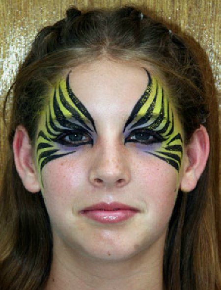 A young girl has her face painted like a tiger