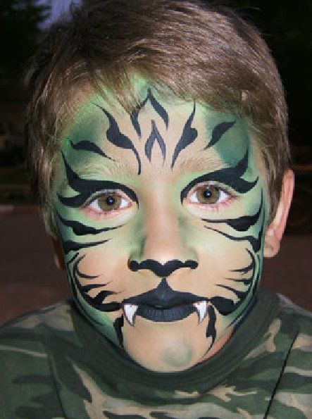 A young boy has his face painted like a tiger