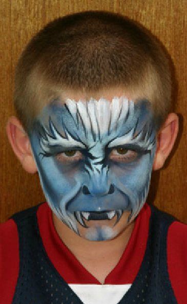 A young boy has his face painted to look like a monster