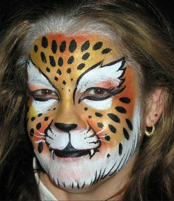 A woman has her face painted like a leopard