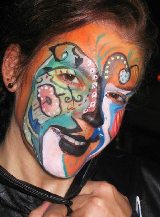 A woman has her face painted with a butterfly design