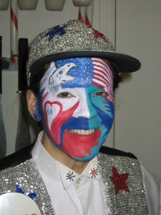 A person with their face painted in the colors of the american flag