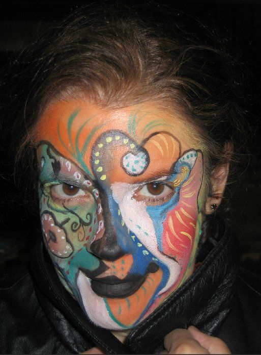 A woman has her face painted in many different colors