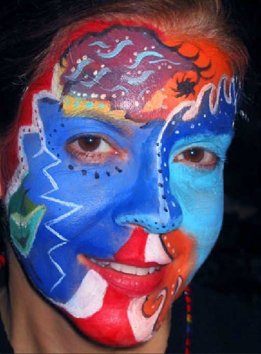 A woman has her face painted in a variety of colors