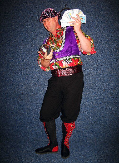 A man in a pirate costume is holding a ball and playing cards