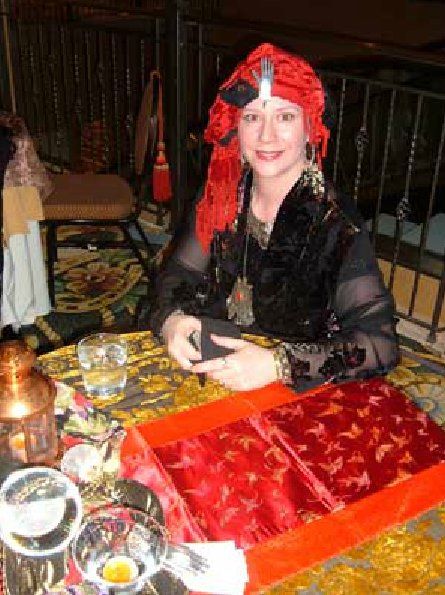 A woman wearing a red turban is sitting at a table