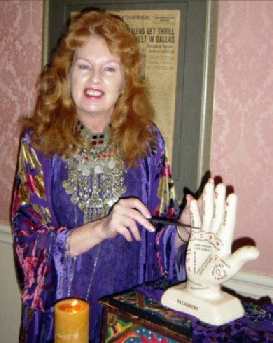 A woman in a purple dress is holding a model of a hand