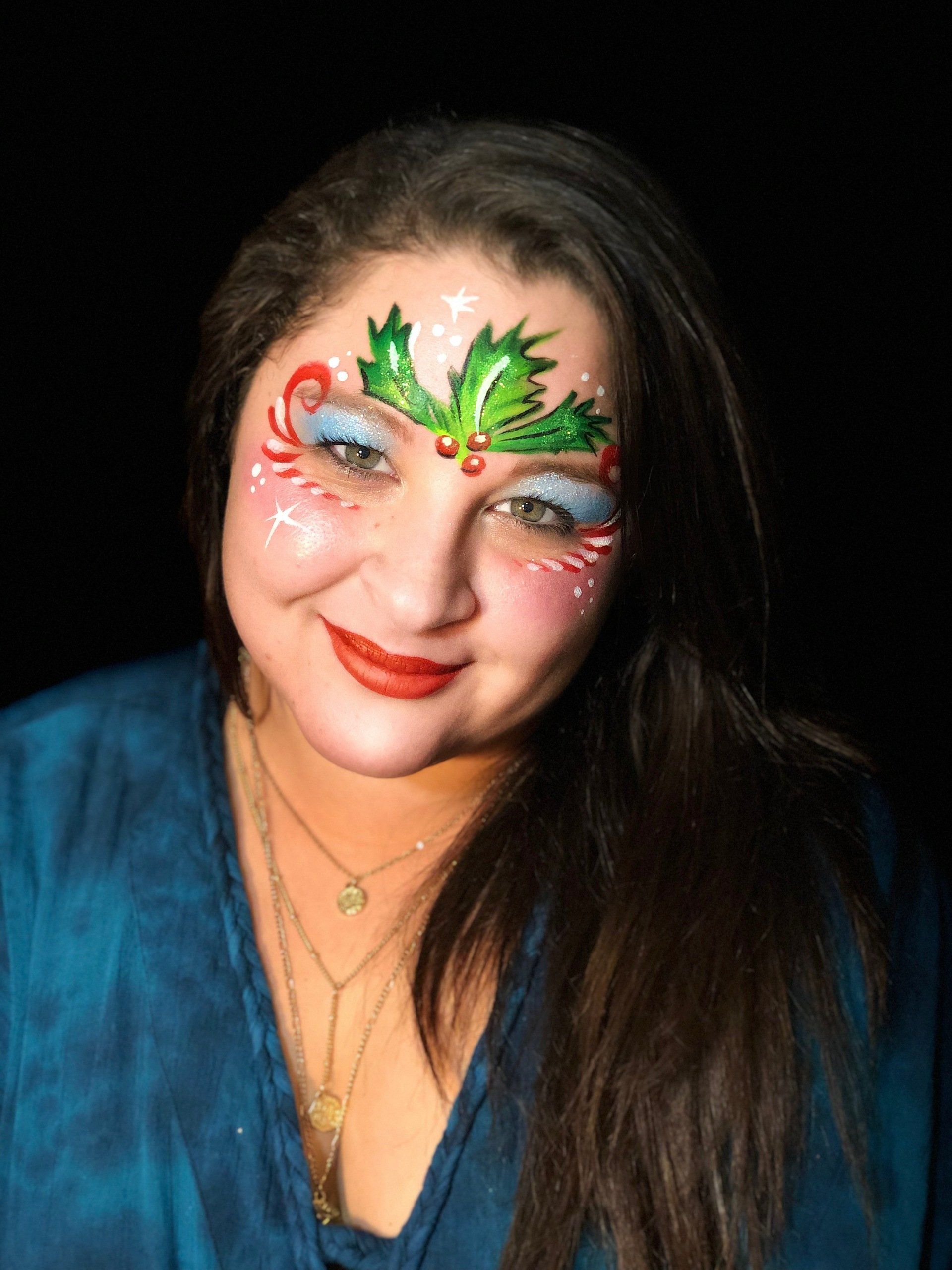 A woman with a candy cane and holly painted on her face