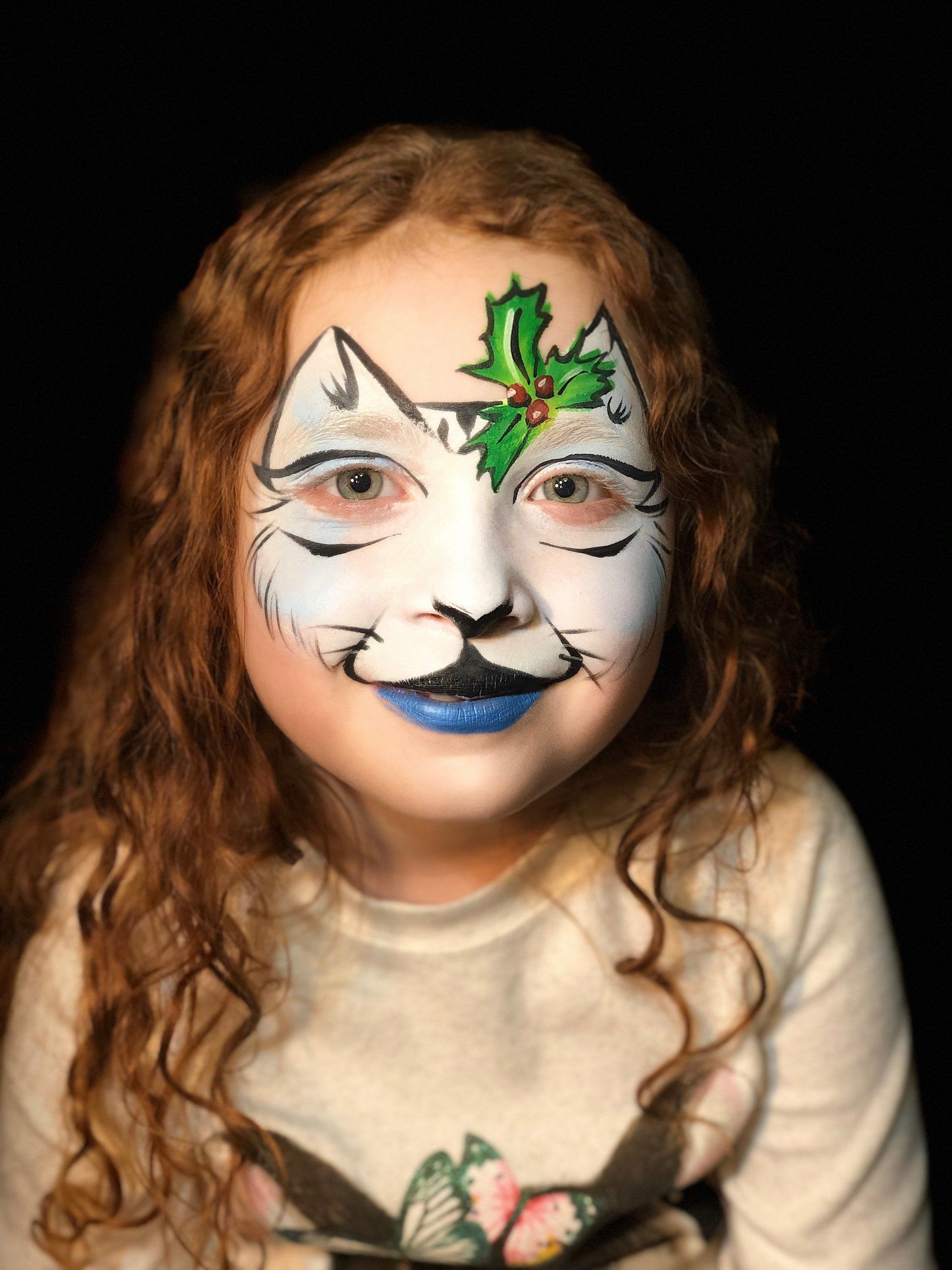A little girl with her face painted like a cat