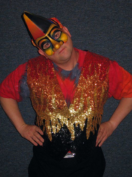 A man in a clown costume has his hands on his hips