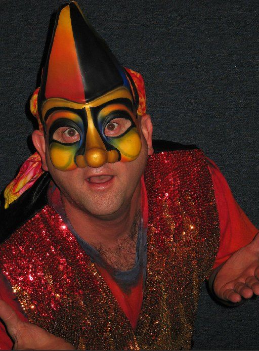 A man wearing a colorful mask and a red vest