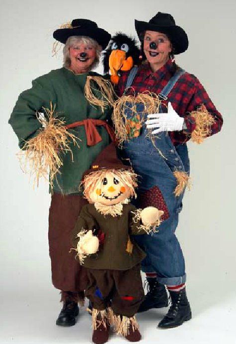 Three people dressed as scarecrows are posing for a picture