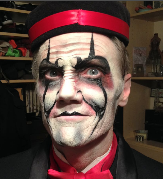 A man with his face painted like a clown