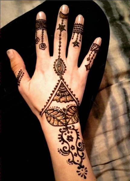 A woman 's hand with a henna design on it