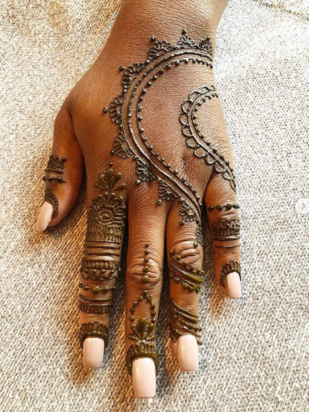 A close up of a woman 's hand with henna on it