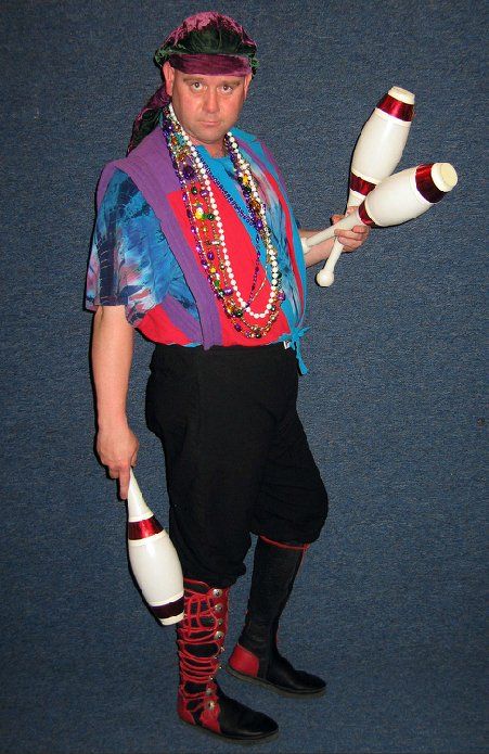 A man in a pirate costume is juggling three juggling pins