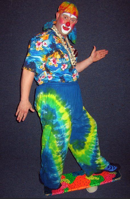 A man dressed as a clown is riding a skateboard