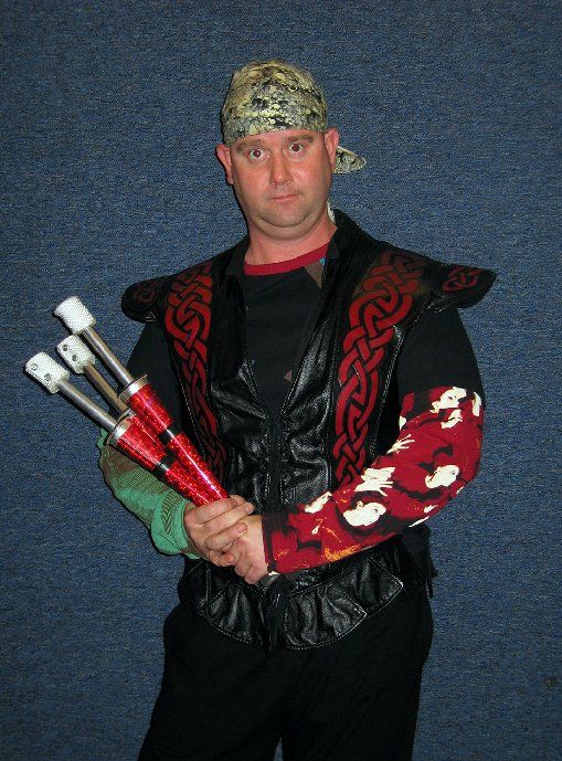 A man with a bandana on his head is holding three sticks