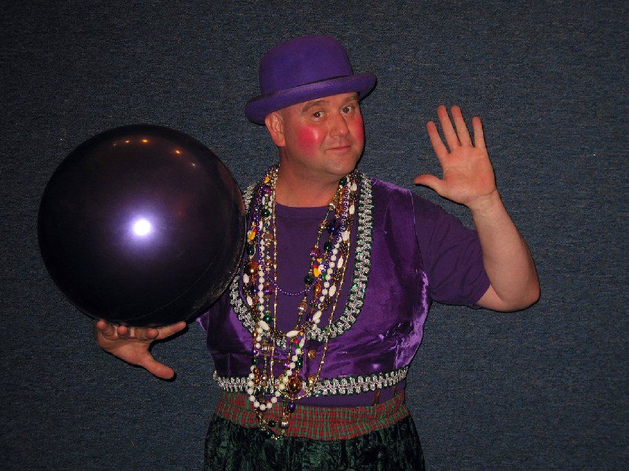 A man in a purple hat is holding a purple balloon