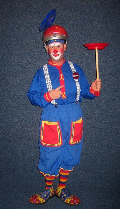 A clown is holding a red plate on a stick