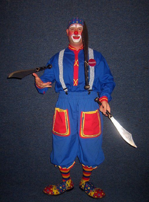 A clown in a blue and red outfit is holding two knives