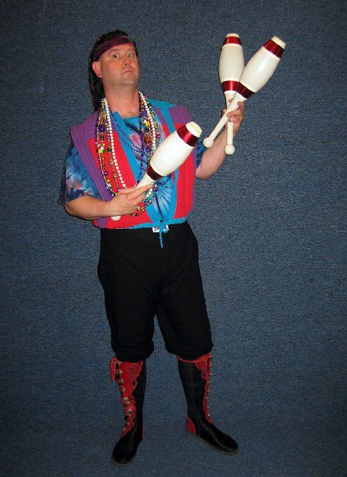A man in a colorful outfit is juggling two juggling pins