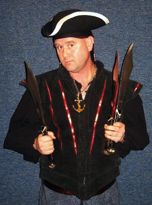 A man in a pirate costume is holding two swords