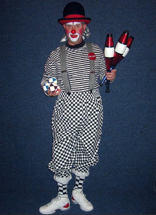 A clown is holding a juggling stick and a cube