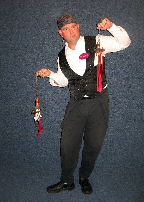 A man in a tuxedo is holding two bells in his hands