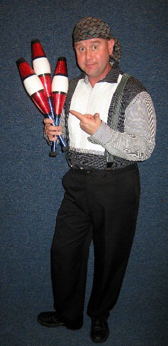 A man in a bandana is holding a bunch of juggling pins.