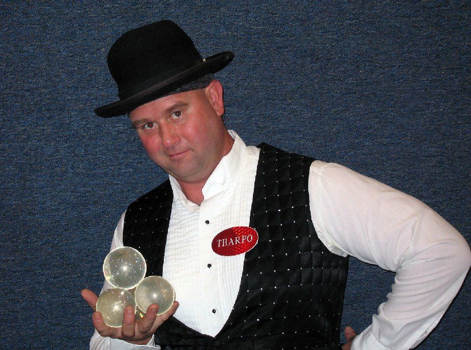 A man wearing a top hat and a vest with a tag that says team