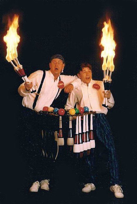 Two men are holding flaming torches in their hands