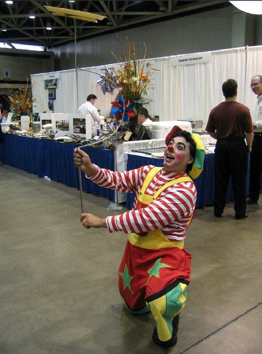 A clown is kneeling down and holding a ladle