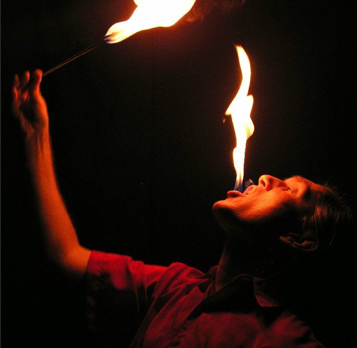 A man is blowing flames out of his mouth