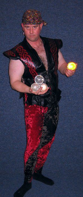 A man in a black and red outfit is juggling balls
